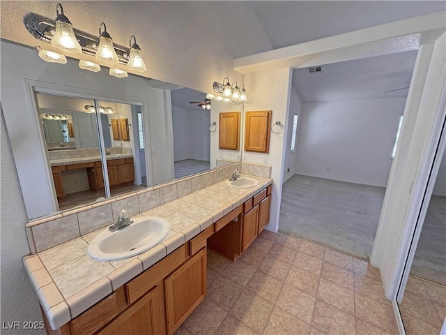 bathroom featuring double vanity, ceiling fan, visible vents, and a sink