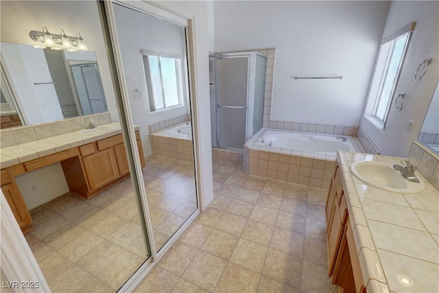 bathroom featuring a garden tub, two vanities, a sink, and a shower stall