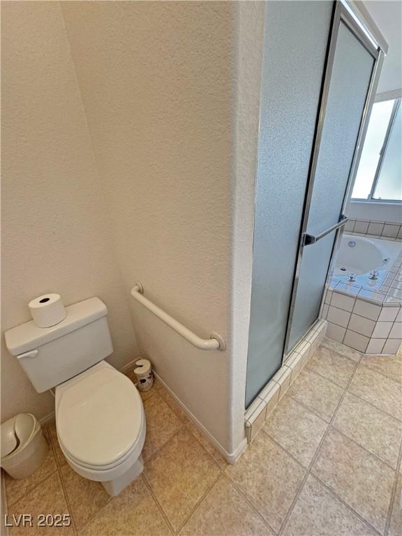 full bathroom featuring toilet, baseboards, a shower stall, a bath, and tile patterned floors