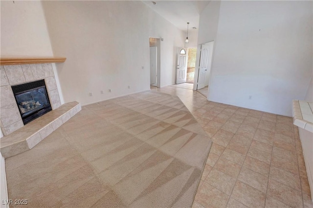unfurnished living room with a fireplace and high vaulted ceiling
