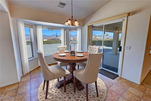 dining space with vaulted ceiling, plenty of natural light, a chandelier, and visible vents