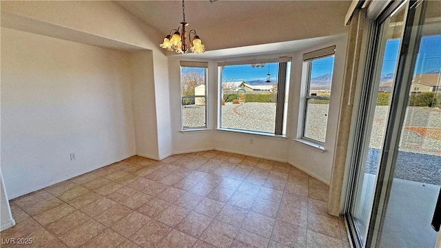 empty room with a chandelier, lofted ceiling, and baseboards