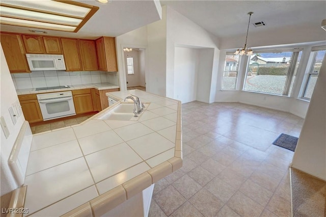 kitchen featuring a notable chandelier, tile countertops, visible vents, a sink, and white appliances