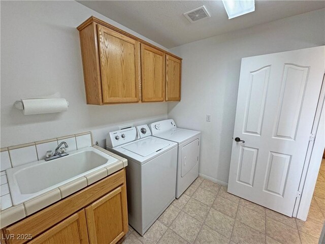 laundry room featuring light floors, cabinet space, visible vents, a sink, and washer and dryer