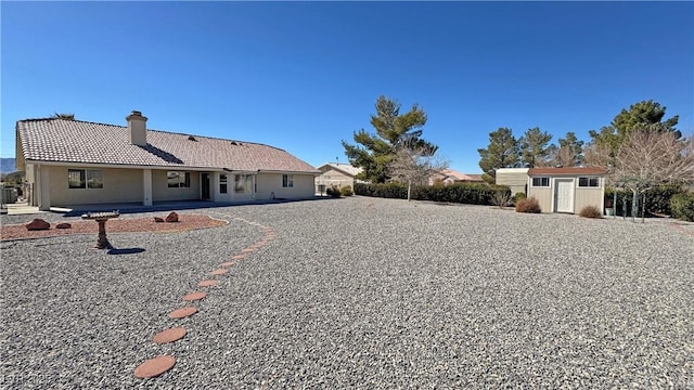 view of yard with an outbuilding, a patio, a shed, and fence