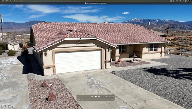 ranch-style house with a tile roof, stucco siding, concrete driveway, an attached garage, and a mountain view