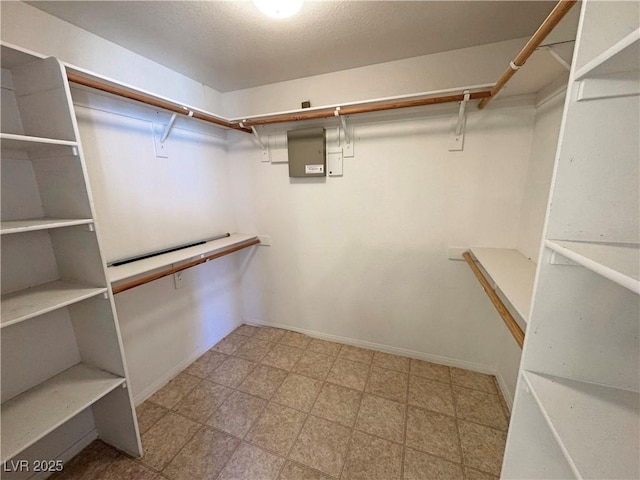 spacious closet with electric panel and tile patterned floors