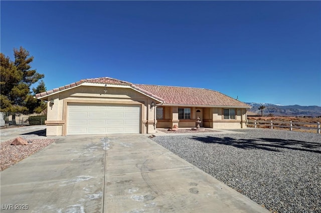 ranch-style home featuring stucco siding, fence, a garage, driveway, and a tiled roof