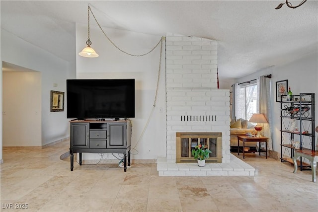 living room with a brick fireplace, a textured ceiling, and baseboards