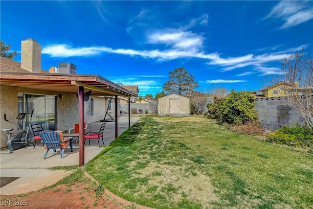 view of yard with a storage unit, a patio area, a fenced backyard, and an outdoor structure