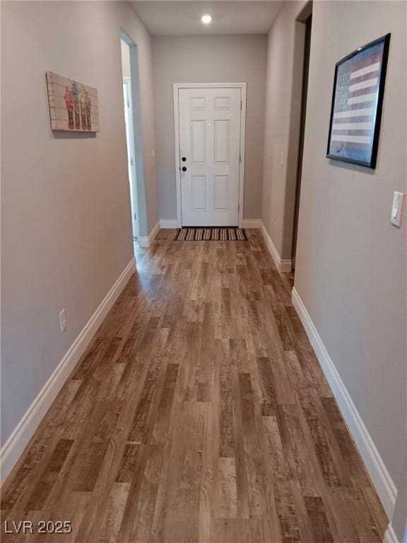 hall with baseboards and wood finished floors