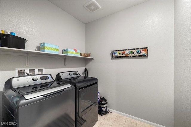 washroom with light tile patterned floors, laundry area, separate washer and dryer, visible vents, and baseboards