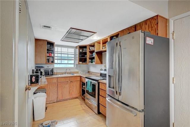 kitchen with open shelves, stainless steel appliances, visible vents, light wood-style floors, and a sink