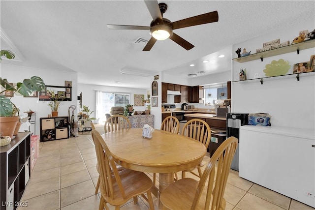 dining space with visible vents, a textured ceiling, and light tile patterned floors