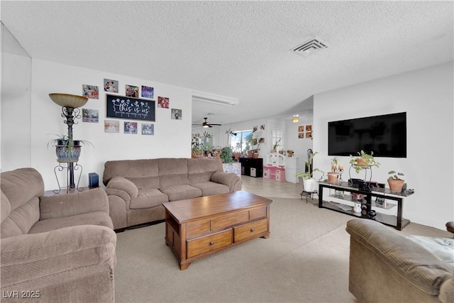 living area featuring a textured ceiling, ceiling fan, and visible vents