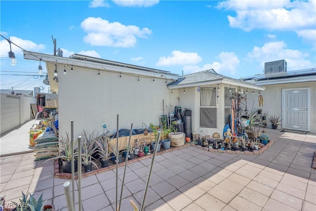 rear view of property with a patio, fence, and stucco siding