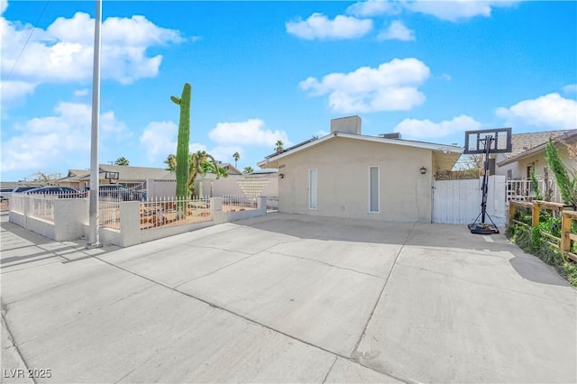 exterior space featuring a fenced front yard, a gate, and stucco siding