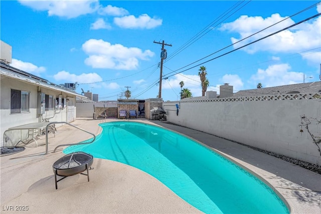 view of swimming pool featuring a fire pit, a patio area, a fenced backyard, and a fenced in pool