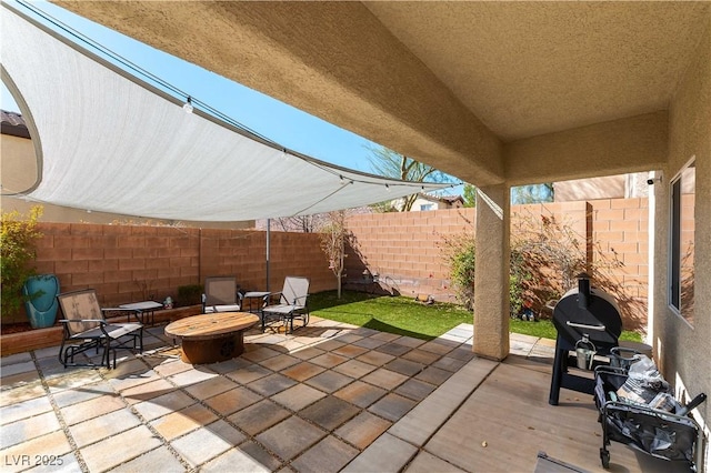 view of patio with an outdoor fire pit and a fenced backyard