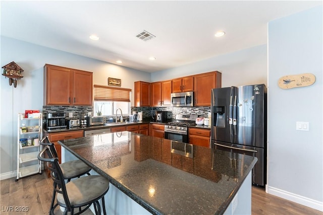 kitchen with stainless steel appliances, tasteful backsplash, a sink, and visible vents