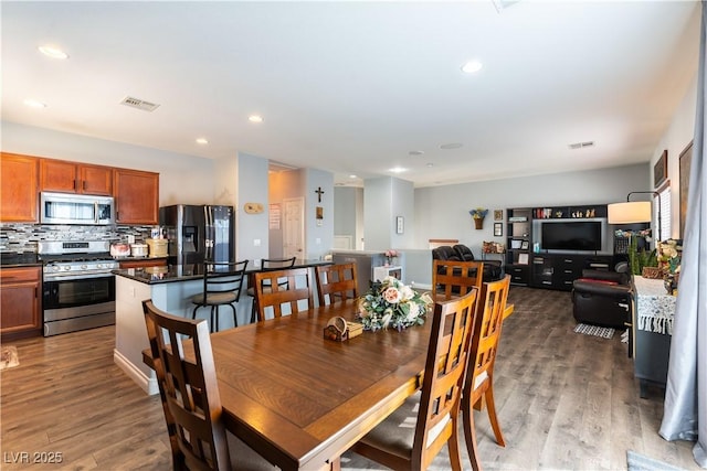 dining space with wood finished floors, visible vents, and recessed lighting