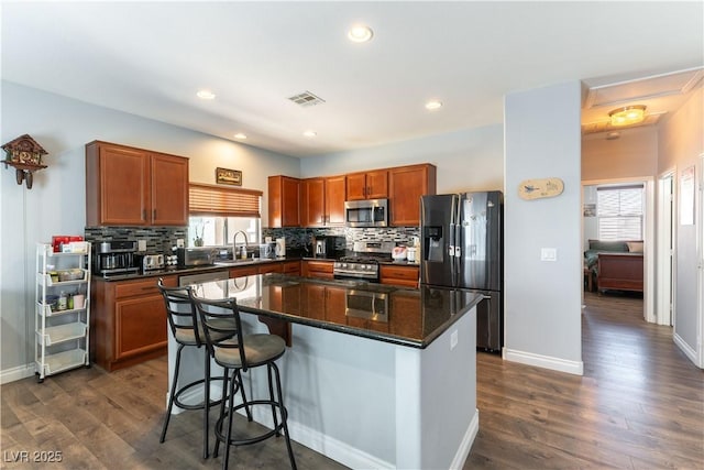 kitchen featuring appliances with stainless steel finishes, decorative backsplash, and a healthy amount of sunlight