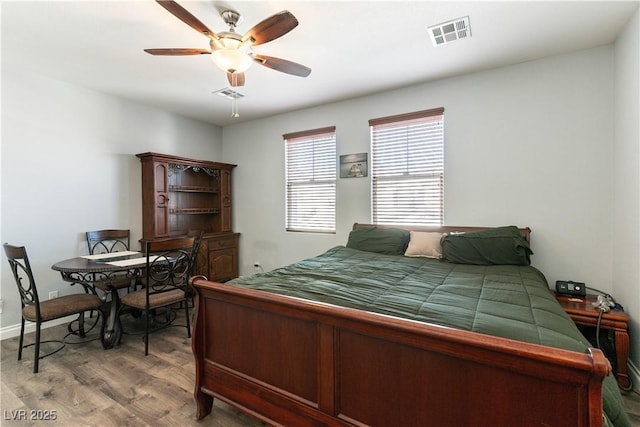 bedroom featuring ceiling fan, light wood finished floors, and visible vents