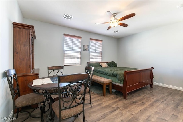 bedroom with light wood-style floors, baseboards, visible vents, and a ceiling fan