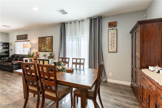 dining space featuring dark wood-type flooring, visible vents, and baseboards