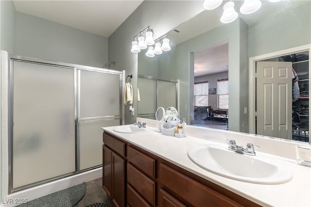 full bathroom with double vanity, a shower stall, visible vents, and a sink