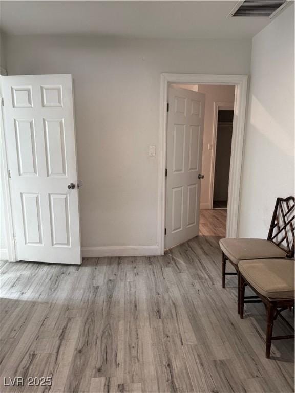 spare room featuring visible vents, baseboards, and wood finished floors