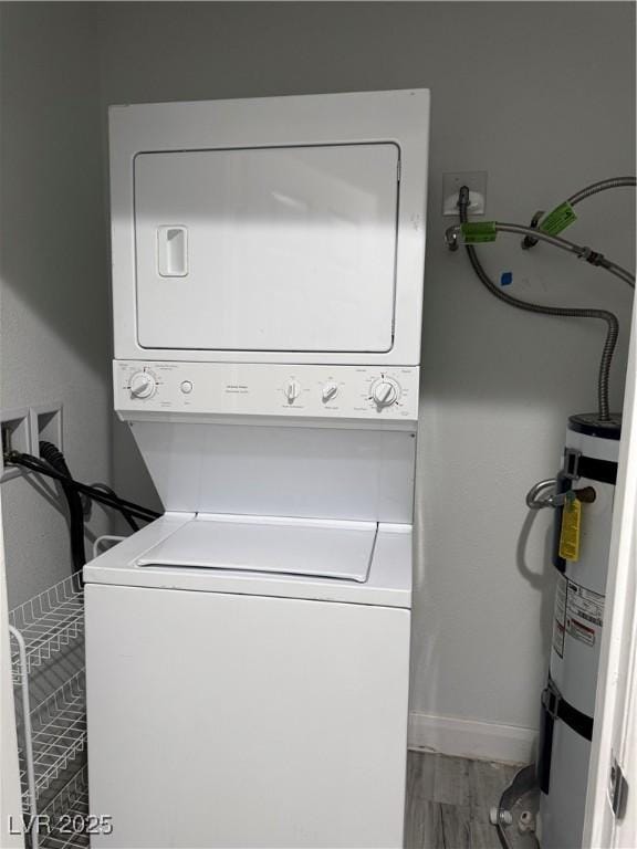 washroom featuring stacked washer and dryer, wood finished floors, secured water heater, and laundry area