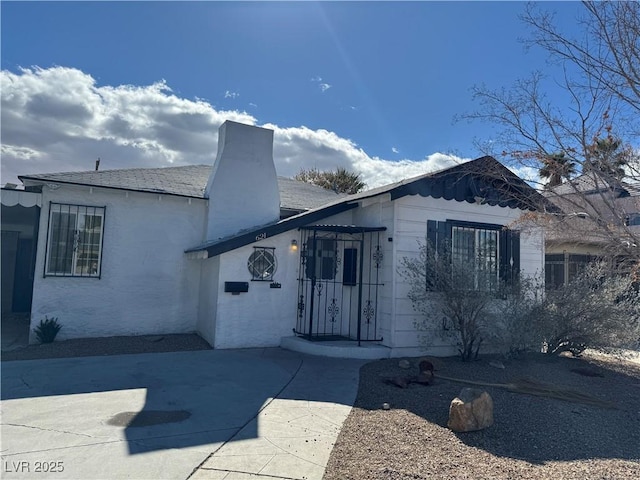 view of front of home featuring a patio and a chimney