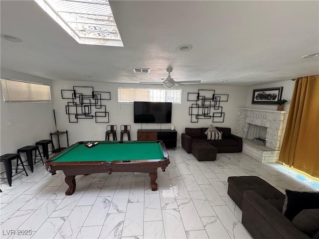 rec room with billiards, visible vents, a fireplace with raised hearth, ceiling fan, and marble finish floor