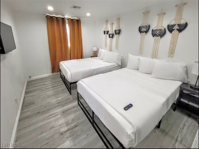 bedroom with visible vents, baseboards, wood finished floors, and recessed lighting