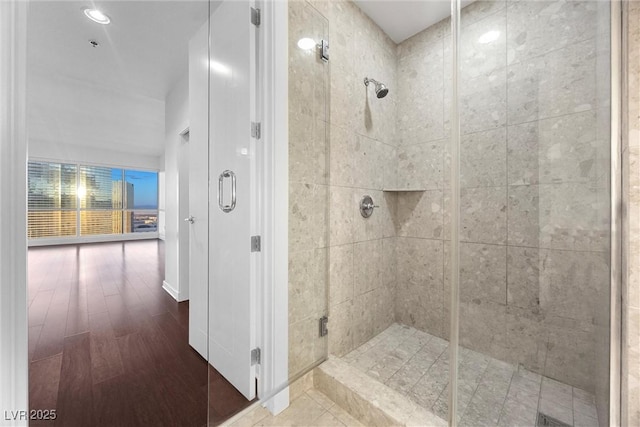 bathroom with a shower stall and wood finished floors