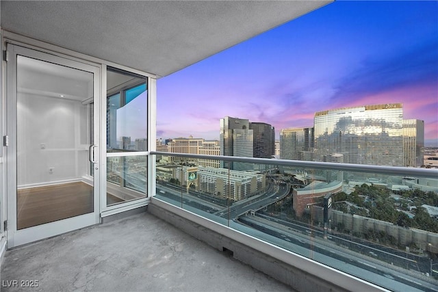 balcony at dusk featuring a city view