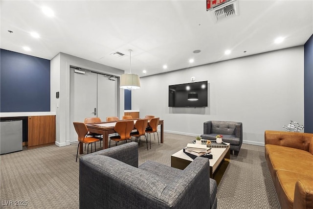 carpeted living area featuring baseboards, visible vents, and recessed lighting