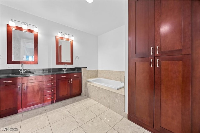 full bathroom with double vanity, a garden tub, a sink, and tile patterned floors