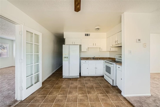 kitchen with dark countertops, visible vents, white cabinets, a sink, and white appliances