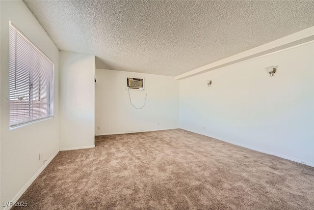 carpeted spare room featuring a textured ceiling and a wall mounted AC