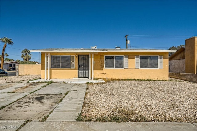 view of front facade featuring fence and stucco siding