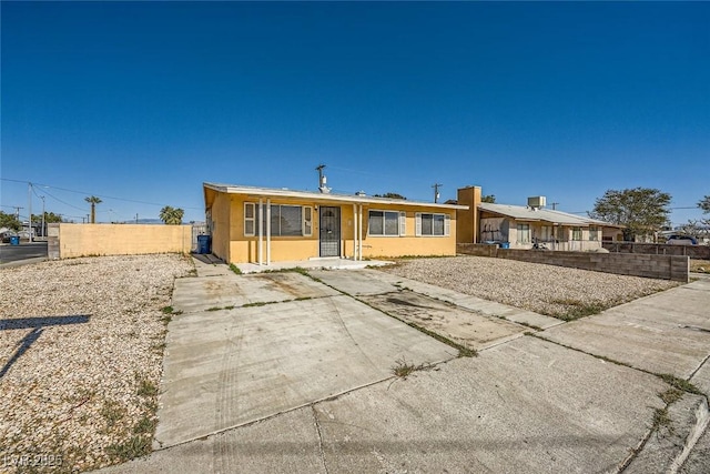 view of front facade with fence and stucco siding