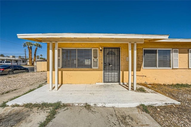 entrance to property featuring stucco siding