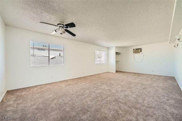 empty room featuring an AC wall unit, carpet, and a ceiling fan