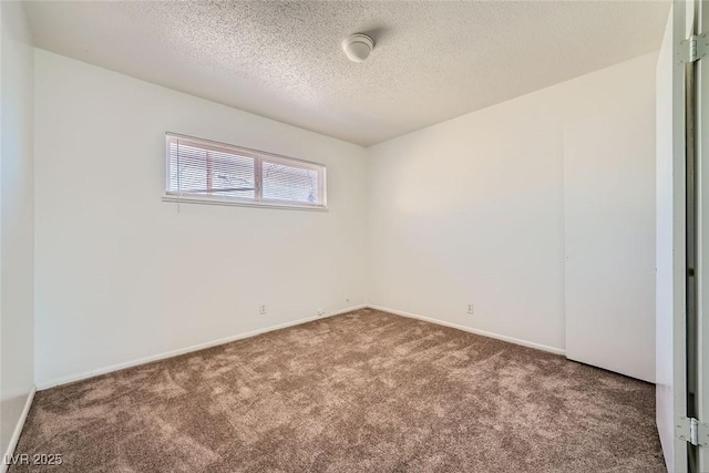 carpeted empty room with a textured ceiling and baseboards