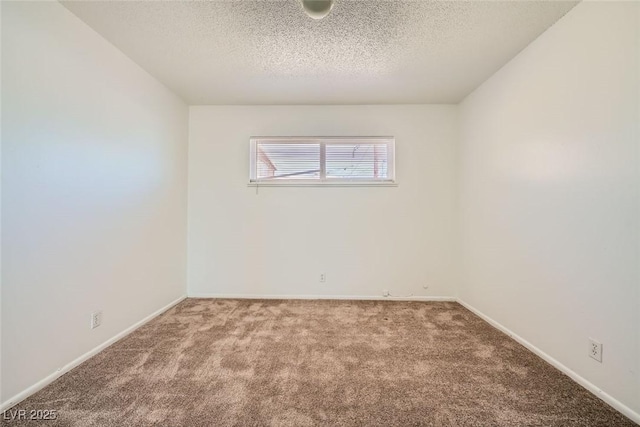 carpeted empty room with a textured ceiling and baseboards