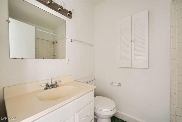 full bathroom featuring a shower, vanity, and toilet