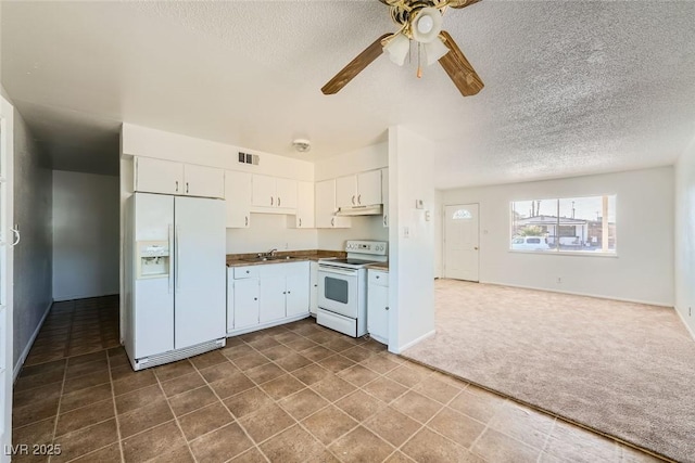 kitchen featuring dark countertops, visible vents, dark carpet, white appliances, and under cabinet range hood