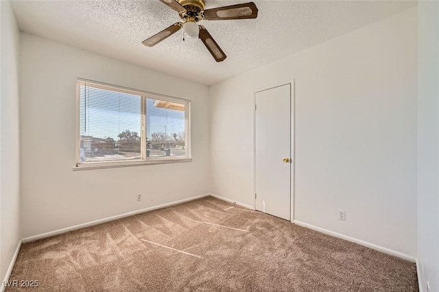 spare room with carpet floors, a ceiling fan, baseboards, and a textured ceiling